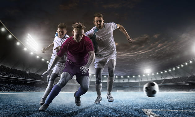 Un contrasto di gioco tra due calciatori durante una partita in notturna