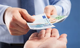 Uno scambio di banconote tra due mani