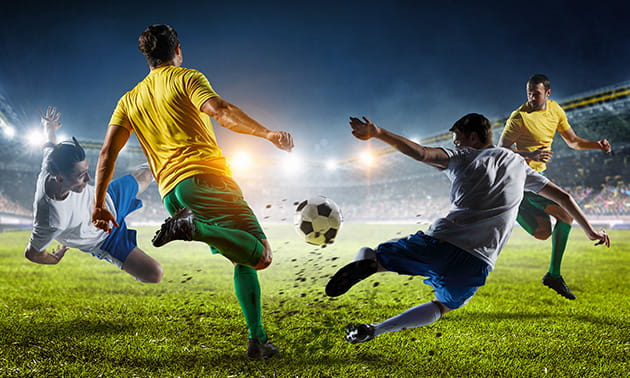 Un contrasto di gioco tra due calciatori durante una partita in notturna